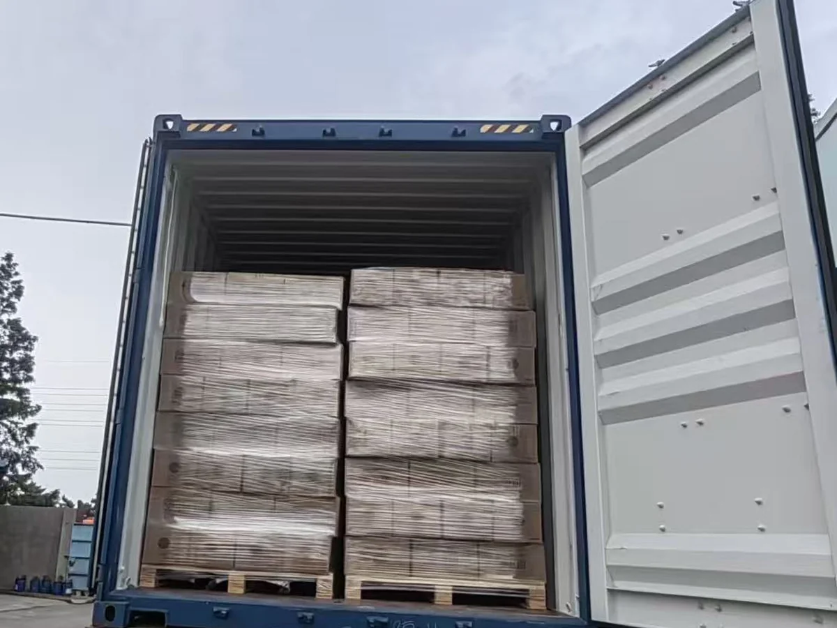 Shrink-wrapped pallets of cat litter loaded in an open container.