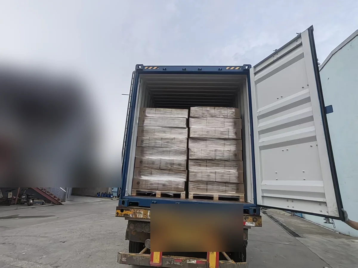 Palletised product loaded into a container, with identifying details blurred for privacy.